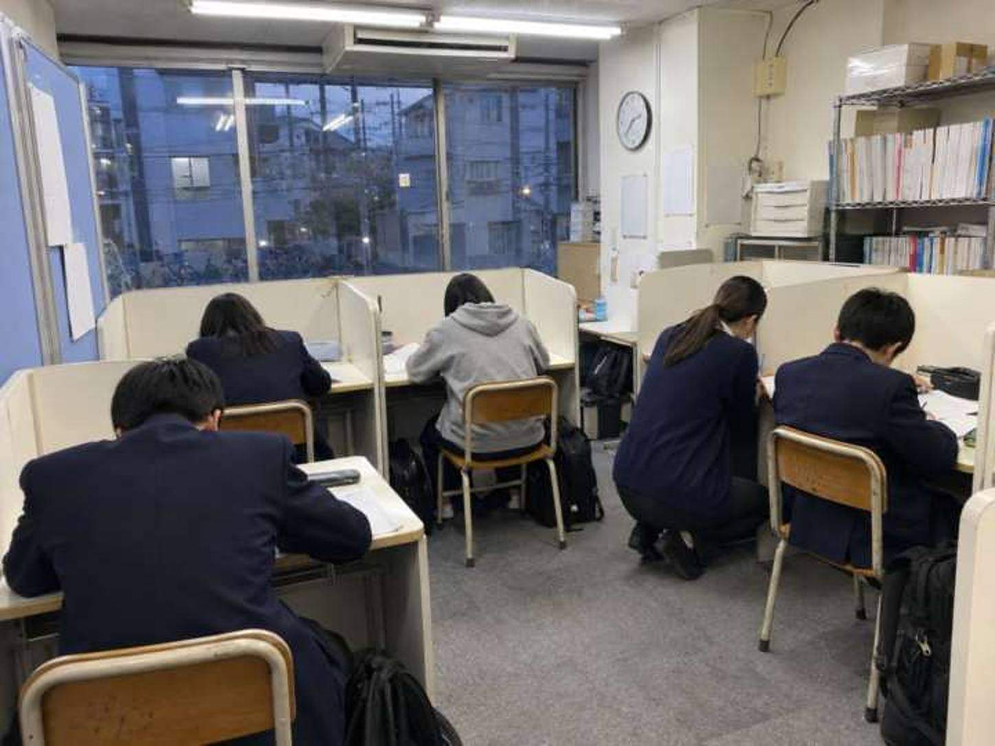 授業中の教室。先生が生徒の横で教えている
